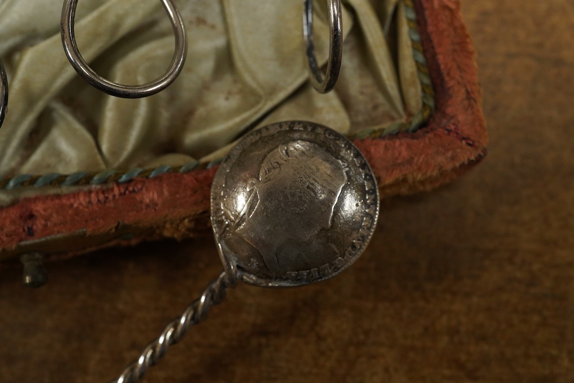 A cased set of twelve assorted white metal coffee spoons, with spiral stems and coin bowls.
